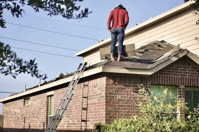 Professional roofer working on a residential roof in West Branch